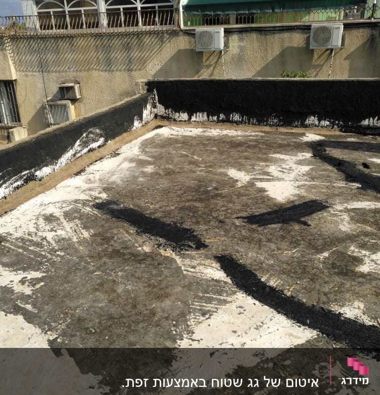 גג עם שכבת איטום ביטומנית שחורה ולבנה